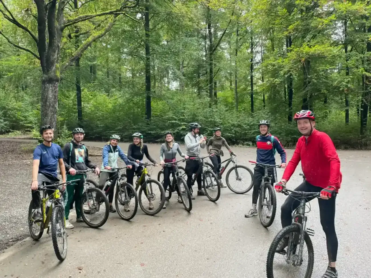 Colleagues with mountain bikes on a forest path during a team outing